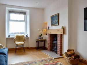 a living room with a brick fireplace and a chair at Harbour View in Johnshaven