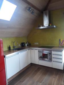 uma cozinha com armários brancos e um lavatório em Studio Nok bij Den Bosch em Den Dungen