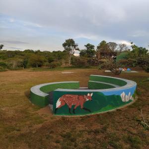 une peinture d'un renard sur un champ vert dans l'établissement Pousada Morro da Baleia, à Alto Paraíso de Goiás