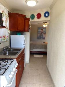 a kitchen with a sink and a stove top oven at Fishtail Palms - Sapodilly in Stuart Manor