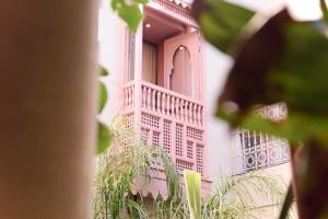 un edificio rosa con balcone sul lato di Riad 117 a Marrakech