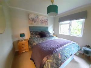 een slaapkamer met een bed en een raam bij Willow Lodge Auchterarder in Auchterarder