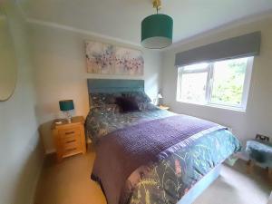 un dormitorio con una cama y una ventana en Willow Lodge Auchterarder, en Auchterarder
