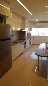 a large kitchen with a table and a refrigerator at Kosher Airbnb very close to Central Bus Station in Jerusalem