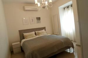 a bedroom with a bed with a chandelier and a window at Kosher Airbnb very close to Central Bus Station in Jerusalem