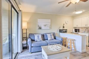 ein Wohnzimmer mit einem blauen Sofa und einer Küche in der Unterkunft Resort Condo Pools, Gym, Bar, Beach and More Onsite in Hilton Head Island