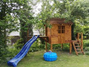 plac zabaw ze zjeżdżalnią i domek na drzewie w obiekcie Nad Bystrą w Nałęczowie