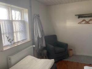 1 dormitorio con 1 cama, 1 silla y 1 ventana en Aasesminde en Fåborg