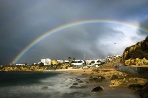 a rainbow over a beach with a beach at Gold Coast Photography Inn in Estoril