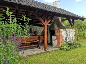 drewniana ławka pod pawilonem w ogrodzie w obiekcie Nad Bystrą w Nałęczowie