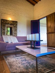 ein Wohnzimmer mit einem lila Sofa und einem Tisch in der Unterkunft Private nature surrounded House with Kiosk/Pool. in Riveralta