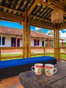 zwei Kaffeetassen auf einem Tisch auf einer Veranda in der Unterkunft Private nature surrounded House with Kiosk/Pool. in Riveralta