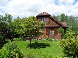una casa de madera con un patio con un árbol en Nad Bystrą en Nałęczów
