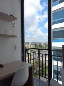 Zimmer mit einem Schreibtisch und Blick auf einen Balkon. in der Unterkunft Aparta estudio acogedor 06-02 in Bogotá