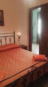 a bed with an orange comforter in a room at B&B IL PALOMBARO in Uggiano la Chiesa