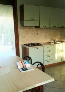 a kitchen with a table and a stove top oven at B&B IL PALOMBARO in Uggiano la Chiesa