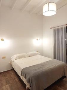 1 dormitorio blanco con 1 cama grande con sábanas blancas en •JADE• Casas de alquiler en Los Molles