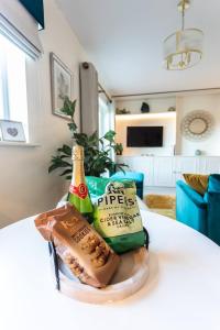 a table with a bottle of beer and some food at Bright, immaculate, luxe Apartment minutes from Warwick - perfect for short & long breaks in Warwick