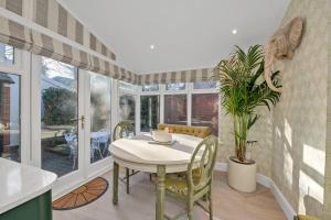 a dining room with a table and a potted plant at 2 Bedroom stylish property set behind the angel hotel with parking and a courtyard garden in Bury Saint Edmunds