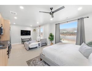 a bedroom with a white bed and a living room at Desert Hideaway in Hurricane