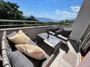 a patio with a couch and chairs on a balcony at Sea View Apartment in Matulji