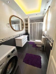 a bathroom with a washing machine and a mirror at Unique apartment in Almaza in Cairo