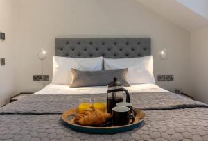 a tray of bread and orange juice on a bed at Cheltenham Two in Harrogate