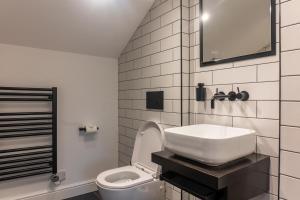 La salle de bains blanche est pourvue d'un lavabo et de toilettes. dans l'établissement Cheltenham Two, à Harrogate