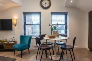 a living room with a table and chairs and a clock at Cheltenham Two in Harrogate