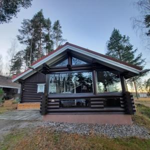 una casa con una gran ventana en la parte delantera en Villa Mustikka, Messilä, en Tiirismaa