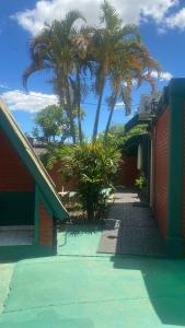 ein Gebäude mit zwei Palmen und einem Bürgersteig in der Unterkunft Iguassu Flower Garden in Puerto Iguazú