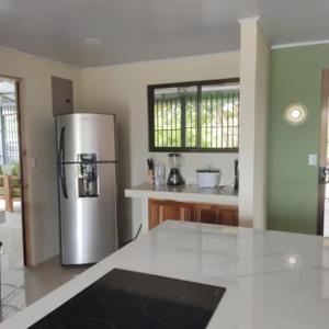 a kitchen with a stainless steel refrigerator in it at The Amigos House-Atelier in Parrita