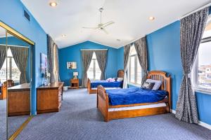two beds in a room with blue walls and windows at Luxe Waterfront Oxnard Getaway with Private Hot Tub! in Oxnard