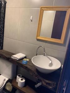 a bathroom with a sink and a mirror and a toilet at CASA CONCEITO - studio panoramico, suites e quartos in São José