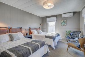 a bedroom with two beds and a blue chair at Auberge des Cantons in Magog-Orford