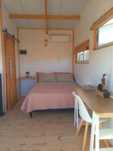 1 dormitorio con cama, mesa y sidx sidx sidx de mesa en Cabaña Paula, playa viuda, en Punta del Diablo