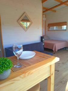 una mesa de madera con una copa de vino encima en Cabaña Paula, playa viuda, en Punta del Diablo