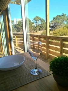 una copa de vino sobre una mesa en Cabaña Paula, playa viuda, en Punta del Diablo