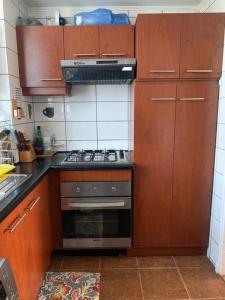 uma cozinha com armários de madeira e um forno com placa de fogão em Hermoso DEPTO en Viña del Mar em Viña del Mar