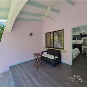 uma sala de estar com um sofá e uma ventoinha de tecto em Tropical Garden Hotel em Jacó