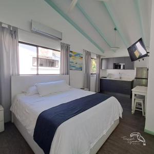 1 dormitorio con 1 cama grande y cocina en Tropical Garden Hotel, en Jacó
