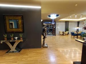 a lobby of a hotel with a statue in the foreground at Queens Leriotis Hotel in Piraeus +41 photos