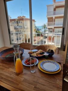 een tafel met borden en een glas sinaasappelsap bij Bolivia Sea View Santa Pola in Santa Pola