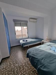 ein Schlafzimmer mit zwei Betten und einem Fenster darin in der Unterkunft Bolivia Sea View Santa Pola in Santa Pola