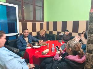 Hotel El ghazi في Villa Bens: مجموعة من الناس يجلسون حول طاولة