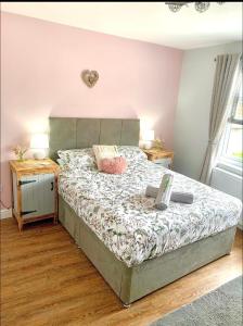 a bedroom with a bed and two tables and a window at Poppy’s Place in Llandudno Junction