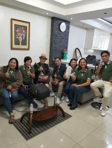 a group of people sitting on a couch in a room at Golden Queen Suites in Baguio