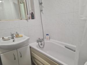 a bathroom with a sink and a bath tub and a sink at Specious Room in Northolt in Northolt