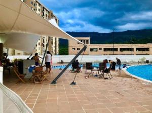 um grupo de pessoas sentadas ao redor de uma piscina em Apartamento para turismo Villeta - para 8 personas em Villeta