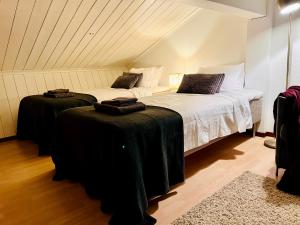 a bedroom with two beds with black blankets at Guestly Homes - 3BR Luxury Beachfront Villa in Piteå